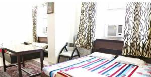 a bedroom with a bed and a desk and a table at OYO Hotel Jk Breeze in Jammu