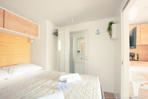 1 dormitorio con 1 cama con 2 toallas en Mobilheim Mate1, en Nin