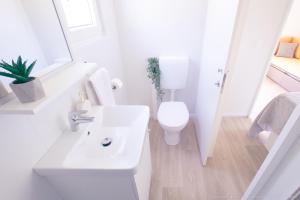 Baño blanco con aseo y lavamanos en Mobilheim Mate1, en Nin