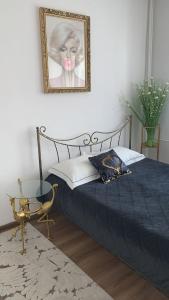 a bedroom with a bed and a picture on the wall at Golden Apartament Legionów in Toruń