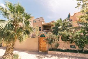 a house with a wooden door and palm trees at The Kozyhome in Ouarzazate
