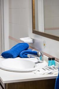 a bathroom sink with a blue towel on it at Apartamentos Maspalomas Foresta in Maspalomas