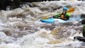 a man in a kayak in the rapids of a river at Rhydydefaid Bed and Breakfast, Guesthouse in Frongoch, Snowdonia in Frongoch
