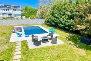 um quintal com uma piscina com cadeiras e uma mesa em Marble & Sun em Hampton Bays