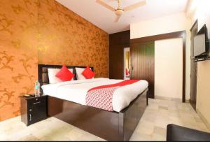 a bedroom with a large bed with red pillows at OYO Royal Den Near Lotus Temple in New Delhi