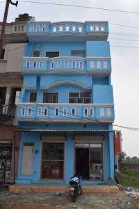 niebieski budynek z motocyklem zaparkowanym przed nim w obiekcie SPOT ON Ashu Guest House w mieście Moradabad