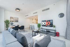 een woonkamer met een bank en een tafel bij Upscale Two Bedroom with Balcony & Free Parking near Zabeel Park by Sojo Stay in Dubai