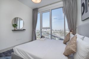 a bedroom with a large bed with a large window at Upscale Two Bedroom with Balcony & Free Parking near Zabeel Park by Sojo Stay in Dubai