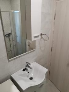 y baño con lavabo blanco y espejo. en AD Apartman Bileća, en Bileća