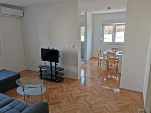 a living room with a couch and a tv and a table at AD Apartman Bileća in Bileća