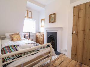 a bedroom with a bed and a fireplace at Crayfish Cottage in Woodbridge