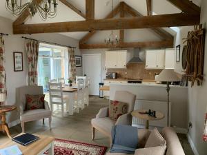 a living room with a couch and a kitchen at Blue Mountain Barn in Scalby