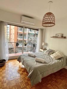 ein Schlafzimmer mit einem Bett und einem großen Fenster in der Unterkunft Excelente piso en el corazón de Palermo -5 PAX- in Buenos Aires