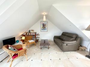 ein Wohnzimmer mit einem Sofa und einem Tisch in der Unterkunft Charmante maison tout confort – Terrasse – Vue sur le port in Locmiquélic