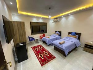 a hotel room with two beds and a television at Black IRIS in Jerash
