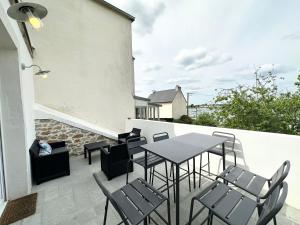 eine Terrasse mit einem Tisch und Stühlen auf dem Balkon in der Unterkunft Charmante maison tout confort – Terrasse – Vue sur le port in Locmiquélic