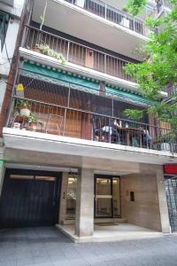 un edificio con personas sentadas en un balcón en Excelente piso en el corazón de Palermo -5 PAX- en Buenos Aires