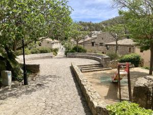 a stone path with a bench in a village at Casa Olivella in Olivella