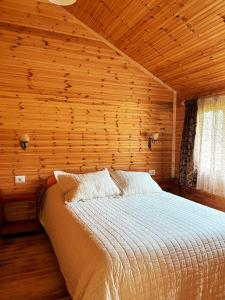 1 dormitorio con 1 cama en una habitación de madera en Farma Sotira, en Leskovik