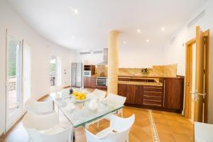 eine Küche mit einem Glastisch und weißen Stühlen in der Unterkunft Bonaire in Cielo de Bonaire 