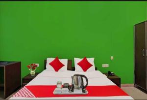 a green bedroom with a bed with a green wall at Flagship Hotel Heaven in Patna