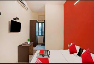 a room with a bed with a red wall at Flagship Hotel Heaven in Patna