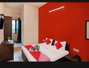 ein Schlafzimmer mit einem Bett mit einer roten Wand in der Unterkunft Flagship Hotel Heaven in Patna