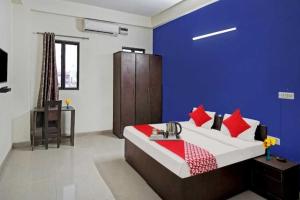 ein Schlafzimmer mit einer blauen Wand und einem Bett mit einem Waschbecken in der Unterkunft Flagship Hotel Heaven in Patna