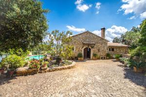 Casa de piedra con piscina y patio en Sa Garriga de Can Barratot, en Selva
