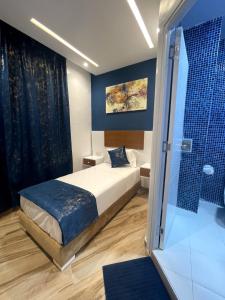 um quarto com uma cama e uma cabina de duche em vidro em HOSTAL MH BORJ em Martil