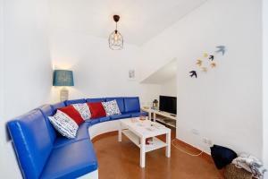 a blue couch in a living room with a table at Casa Branca in Luz