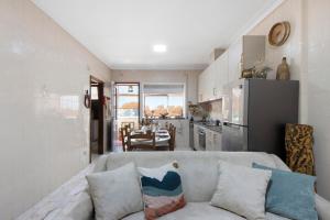 ein Wohnzimmer mit einem Sofa und einer Küche in der Unterkunft Sobreiro22 in Lourosa