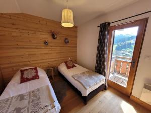 een slaapkamer met 2 bedden en een raam bij Chalet Les Gets, 5 pièces, 6 personnes - FR-1-598-24 in Les Gets