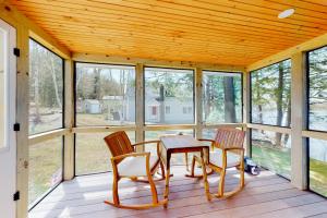 a screened in porch with a table and chairs at Grove Road Lakehouse in Barnard