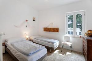 een slaapkamer met 2 bedden en een raam bij Casa romantica in Ispra