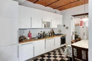 een keuken met witte kasten en een geruite vloer bij Casa romantica in Ispra