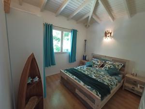 ein Schlafzimmer mit einem Bett mit grüner Bettwäsche und einem Fenster in der Unterkunft Villa 4 étoiles avec piscine, 3 chambres et jardin tropical in Saint-François + 20 Fotos