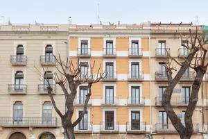 un grande edificio con balconi e alberi di fronte di Andreas Apartments a Tarragona