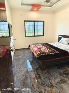 a bedroom with a bed and a flat screen tv at POP Hotel Harsh in Aurangabad