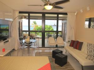 a living room with a couch and a tv and a table at Luxury Beachfront Duplex Villa on Sapphire Beach I in East End