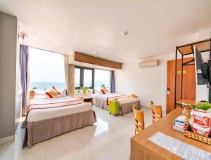 a hotel room with two beds and a table at Arise Seaside Hotel in Nha Trang