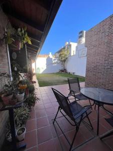 un patio con 2 sillas, una mesa y una pared de ladrillo en Hermosa casa en el corazón de Alta Córdoba en Córdoba