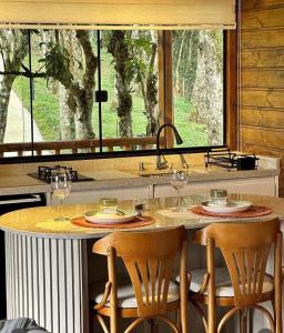 a kitchen with a table with wine glasses on it at CHALES CAMBARA DA SERRA in São José dos Pinhais