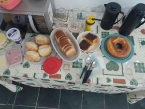a table topped with different types of bread and pastries at Hotel Mar de Minas in Três Marias