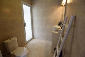 een badkamer met toilet, wastafel en raam bij Chitra villa in Seminyak +13 foto's