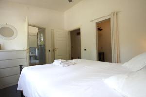 um quarto com uma cama branca e toalhas em Appia Antica 1BR with swimming pool em Roma