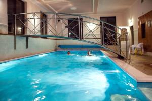 zwei Personen schwimmen in einem Schwimmbecken in der Unterkunft Hotel GOLFER in Kremnitz