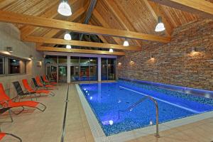 a swimming pool in a building with a brick wall at Hotel Bauer in Bílá