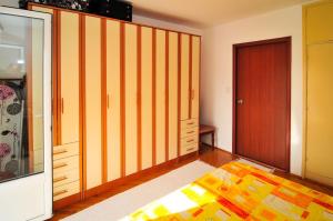 a bedroom with orange and yellow striped walls and a door at Apartmani Andjelka in Tivat