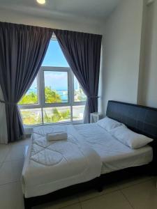 a bed in a bedroom with a large window at Southbay Seaview Condo A10 #10minQueensbay #15minSPICE in Bayan Lepas